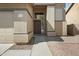 Close-up view of the front door with a small window, textured stucco and low maintenance landscaping at 15346 W Hearn Rd, Surprise, AZ 85379