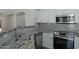 Close-up of stylish kitchen with granite counters, stainless steel appliances and modern backsplash at 15346 W Hearn Rd, Surprise, AZ 85379