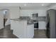Modern kitchen featuring white cabinetry, stainless steel appliances, and a granite countertop breakfast bar at 15346 W Hearn Rd, Surprise, AZ 85379