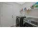 Laundry area with modern Samsung washer and dryer, shelving, and a white door at 15346 W Hearn Rd, Surprise, AZ 85379