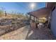 Backyard with rock wall landscaping, covered patio, and natural desert scenery at 1637 E Camino Del Santo --, Phoenix, AZ 85022