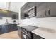 Updated kitchen with dark cabinets, stainless steel appliances, white counters, subway tile, and wood floors at 1637 E Camino Del Santo --, Phoenix, AZ 85022