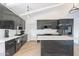Modern kitchen featuring dark cabinets, marble countertops, stainless steel appliances, and light wood flooring at 1637 E Camino Del Santo --, Phoenix, AZ 85022