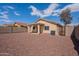 Gravel landscaped backyard featuring a covered patio, and the home's exterior at 168 S 223Rd Dr, Buckeye, AZ 85326