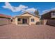 Gravel landscaped backyard featuring a covered patio, the home's exterior, and an air conditioning unit at 168 S 223Rd Dr, Buckeye, AZ 85326