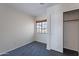 Cozy bedroom featuring neutral-colored carpet, a window with blinds, and a convenient closet space at 168 S 223Rd Dr, Buckeye, AZ 85326