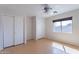 Bright bedroom with a ceiling fan, closet, and large window at 168 S 223Rd Dr, Buckeye, AZ 85326