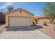 Beige single-story home featuring a two-car garage and a well-maintained front yard with desert landscaping at 168 S 223Rd Dr, Buckeye, AZ 85326