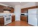 Kitchen featuring white appliances, wood cabinets, and laminate countertops at 168 S 223Rd Dr, Buckeye, AZ 85326