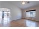 Well-lit living room with wood floors and large windows offering views of the backyard and a doorway to an adjacent room at 168 S 223Rd Dr, Buckeye, AZ 85326