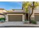 Two-story townhouse featuring a two-car garage, stone accents, desert landscaping and exterior staircase at 20121 N 76Th St # 2064, Scottsdale, AZ 85255