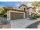 Two-story townhouse with a two-car garage, stone accents, and desert landscaping, showcasing its curb appeal at 20121 N 76Th St # 2064, Scottsdale, AZ 85255