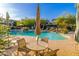 A relaxing community pool area with tables, chairs, umbrellas, and serene water features at 20121 N 76Th St # 2064, Scottsdale, AZ 85255