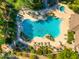 Aerial view of a pool and patio featuring lounge chairs, tables, umbrellas, and mature landscaping at 20121 N 76Th St # 2064, Scottsdale, AZ 85255