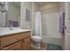 Cozy bathroom with a light wood vanity, toilet, and shower/tub combination with a curtain at 20222 N 267Th Ln, Buckeye, AZ 85396