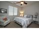 Cozy bedroom with a queen bed, chair, ceiling fan and a window with natural light at 20222 N 267Th Ln, Buckeye, AZ 85396