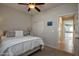 Cozy bedroom with a comfortable queen bed, ceiling fan and a door leading to other rooms at 20222 N 267Th Ln, Buckeye, AZ 85396