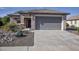 Charming single-story home with desert landscaping featuring rocks, agave, and a driveway at 20222 N 267Th Ln, Buckeye, AZ 85396