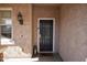 Covered front porch with dark wood door, decorative wall sconce, and lantern at 20222 N 267Th Ln, Buckeye, AZ 85396