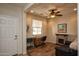 Bright office with stone fireplace, ceiling fan, and wood-look flooring at 20222 N 267Th Ln, Buckeye, AZ 85396