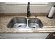 Stainless steel double basin kitchen sink with granite countertops and modern black faucet at 20222 N 267Th Ln, Buckeye, AZ 85396