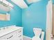 Bright turquoise bathroom featuring white cabinets, black and white tile floors, and shower with tub at 2049 W Joan De Arc Ave, Phoenix, AZ 85029