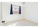Neutral bedroom featuring tile floors, closet, and large window with dark blue curtains at 2049 W Joan De Arc Ave, Phoenix, AZ 85029