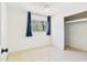 Light bedroom featuring tile floors, a closet, and a window with dark blue curtains at 2049 W Joan De Arc Ave, Phoenix, AZ 85029