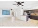 Open concept living room and kitchen with tile floors, ceiling fans, and stainless steel appliances at 2049 W Joan De Arc Ave, Phoenix, AZ 85029