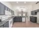 Open-concept kitchen with gray cabinets, granite counters, and white appliances flows to the living area at 2101 S Meridian Rd # 26, Apache Junction, AZ 85120
