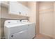 This laundry room features a white washer and dryer with upper cabinets at 2101 S Meridian Rd # 26, Apache Junction, AZ 85120