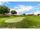 Lush putting green with manicured lawn and mature trees, perfect for practicing your short game at 2101 S Meridian Rd # 26, Apache Junction, AZ 85120