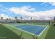Outdoor tennis courts with blue playing surface, surrounded by lush greenery and secure fencing for recreational play at 2101 S Meridian Rd # 26, Apache Junction, AZ 85120