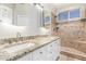 Bathroom with double sink vanity, stone countertops, decorative tile, and walk-in shower at 21313 N 59Th Dr, Glendale, AZ 85308
