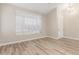 Neutral-toned living room featuring wood floors, a large window, and a front door at 21313 N 59Th Dr, Glendale, AZ 85308