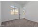 This bedroom features neutral carpet, a window for natural light, and a doorway leading to another room at 21846 E Bonanza Ct, Queen Creek, AZ 85142
