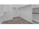 Spacious walk-in closet providing ample storage space with custom shelving and carpeted floor at 21846 E Bonanza Ct, Queen Creek, AZ 85142