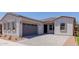 Stylish single-story home with a gray garage door and stone driveway at 21846 E Bonanza Ct, Queen Creek, AZ 85142