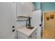 Functional laundry room with white cabinets, a modern sink, and a stacked washer and dryer unit at 23455 S 199Th Pl, Queen Creek, AZ 85142