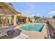 Backyard pool area features lounge chairs, an umbrella for shade, mature landscaping and exterior access at 23455 S 199Th Pl, Queen Creek, AZ 85142