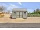 Exterior of a well-maintained storage shed with double doors and a wooden ramp in the backyard at 23455 S 199Th Pl, Queen Creek, AZ 85142