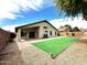 Spacious backyard with faux grass, brick patio, and desert landscaping at 2409 N 112Th Ln, Avondale, AZ 85392