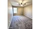 Carpeted bedroom with neutral-colored walls, a ceiling fan, and a window, offering a cozy atmosphere at 2409 N 112Th Ln, Avondale, AZ 85392