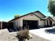 Property featuring an open three-car garage, desert landscaping, and a private fenced-in area at 2409 N 112Th Ln, Avondale, AZ 85392