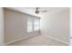 Neutral bedroom features two windows, a ceiling fan, and plush carpet at 2509 W Seaver Ave, Apache Junction, AZ 85120