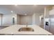 A modern kitchen features an island with a sink, stainless steel refrigerator, and open living space at 2509 W Seaver Ave, Apache Junction, AZ 85120
