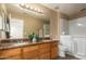 Well-lit bathroom with dual sinks, granite countertop, and accessible walk-in shower tub at 252 S Canfield --, Mesa, AZ 85208