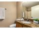 Neutral bathroom featuring a granite countertop, wooden vanity, and a clean white toilet at 252 S Canfield --, Mesa, AZ 85208