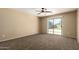Neutral-toned bedroom with sliding glass door to backyard, ceiling fan, and plush carpeting at 252 S Canfield --, Mesa, AZ 85208