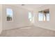 Bright, carpeted bedroom with three windows, baseboards, and neutral paint at 25308 N 133Rd Ave, Peoria, AZ 85383
